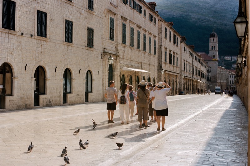 Morning light shines off the polished limestone paving of Stradun in Dubrovnik's Old Town, shutters still closed above