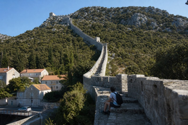 Morning sun climbing the long medieval defensive walls of Ston on Croatia's Pelješac peninsula, an early stop on a day trip from Dubrovnik