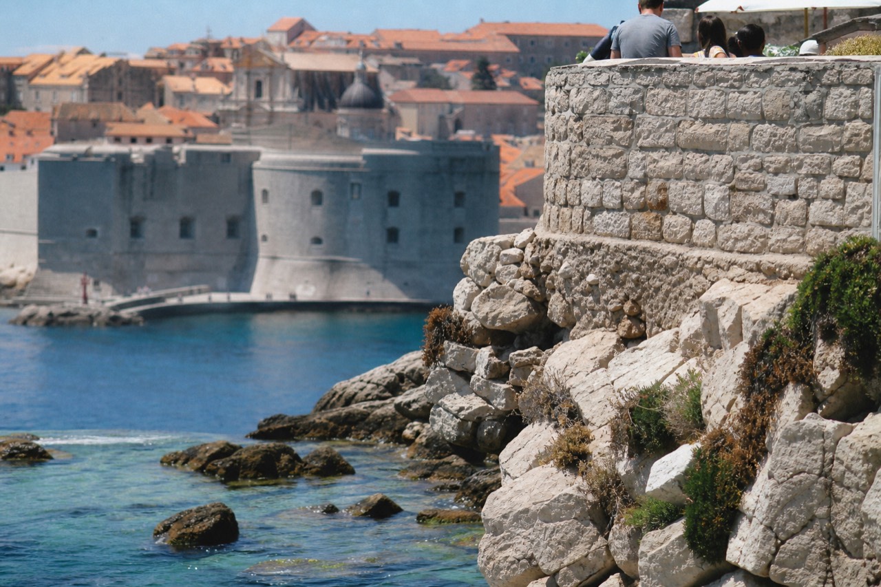 The walled Old Town of Dubrovnik seen from the Adriatic Sea with terracotta roofs and a stone fortress