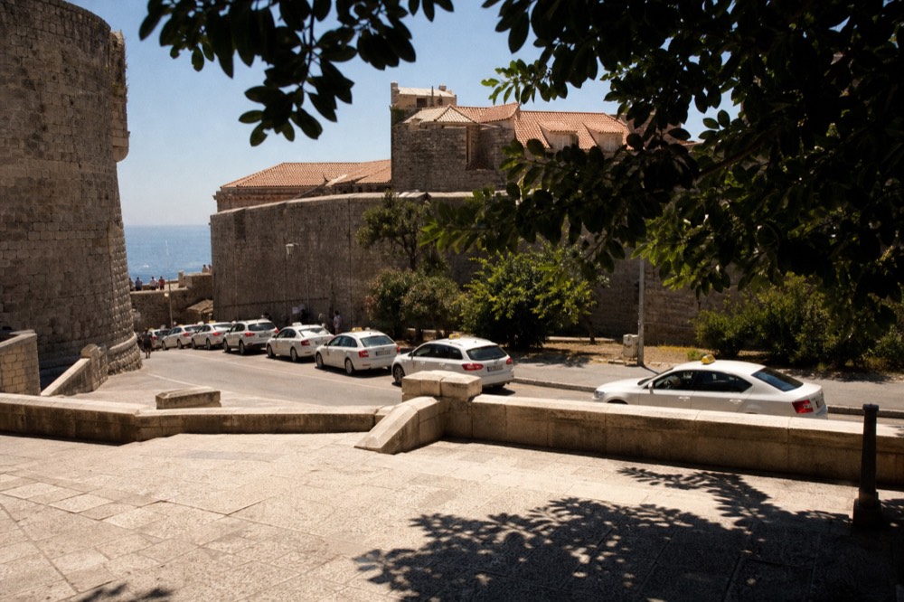 A line of taxis waiting on the road outside the medieval city walls near Pile Gate