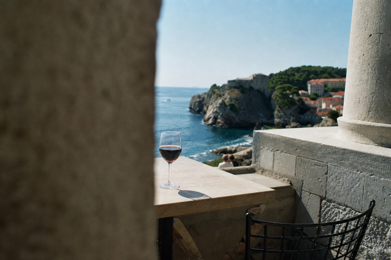 A glass of red wine on a stone terrace above the Adriatic sea near Dubrovnik