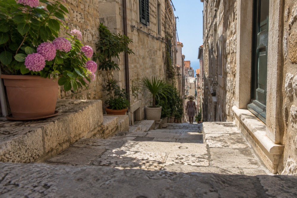 A narrow stepped side lane climbing away from the main street between tall stone houses