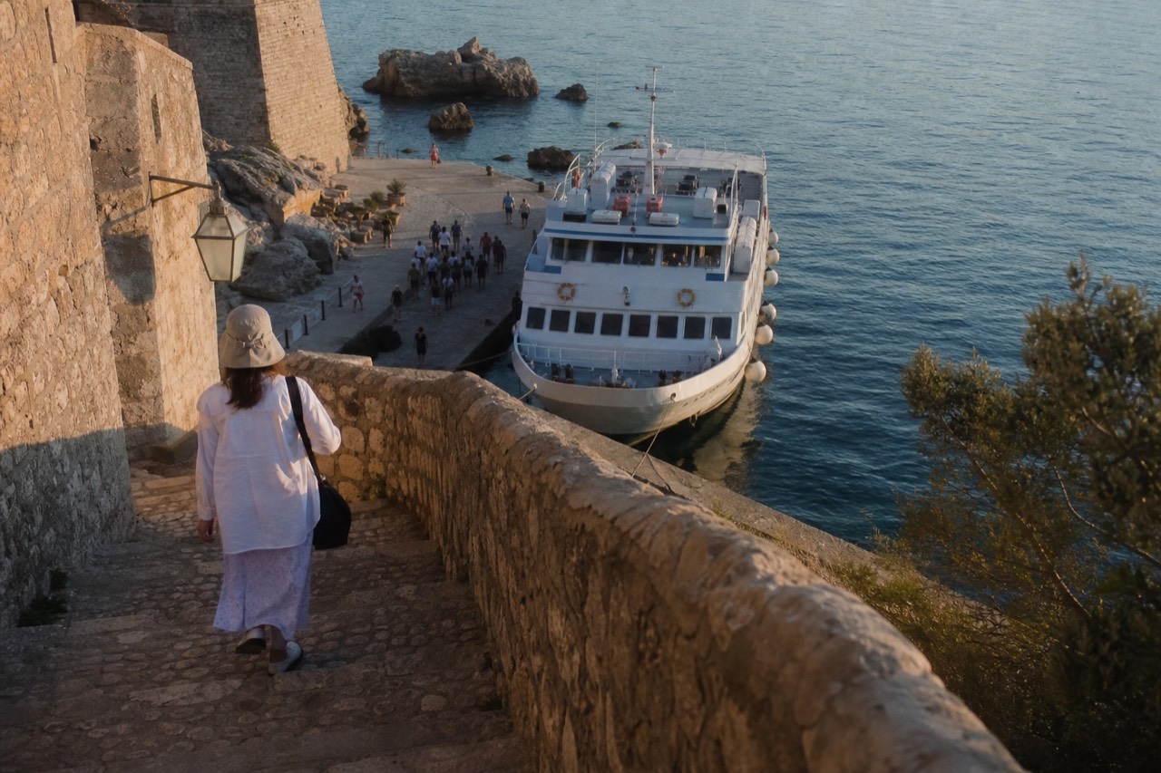 A passenger ferry moored at a stone quay on a calm Adriatic morning