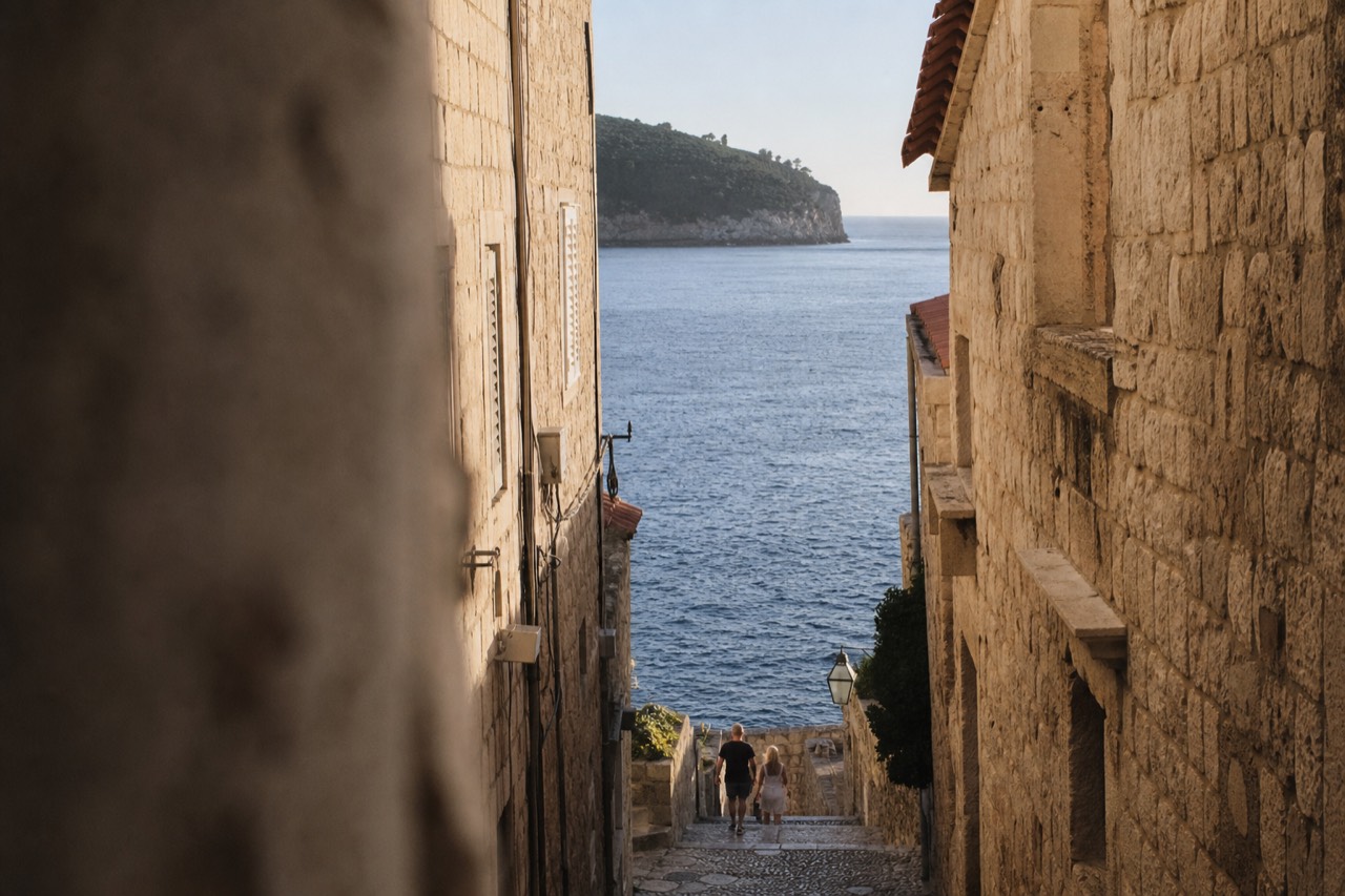Sunlit limestone street inside Dubrovnik Old Town with stone buildings on both sides