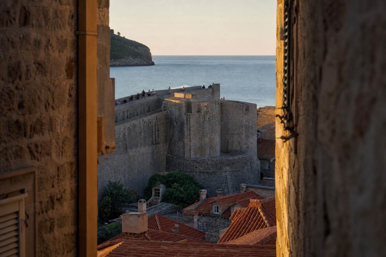 Stone city walls rising above red rooftops and the Adriatic sea