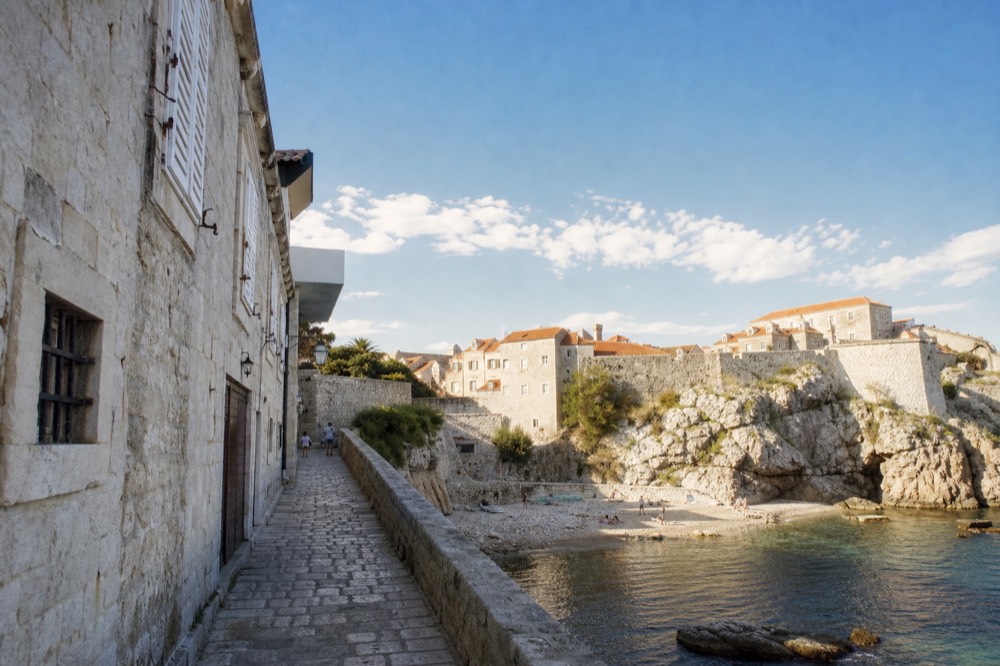 Limestone-paved street in Dubrovnik Old Town with stone facades and shuttered windows
