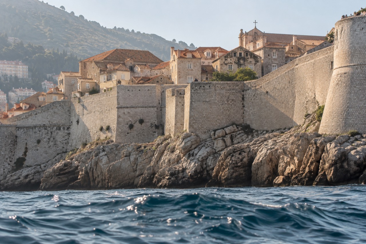 Stone buildings and terracotta roofs of Dubrovnik Old Town seen from the city walls above the sea