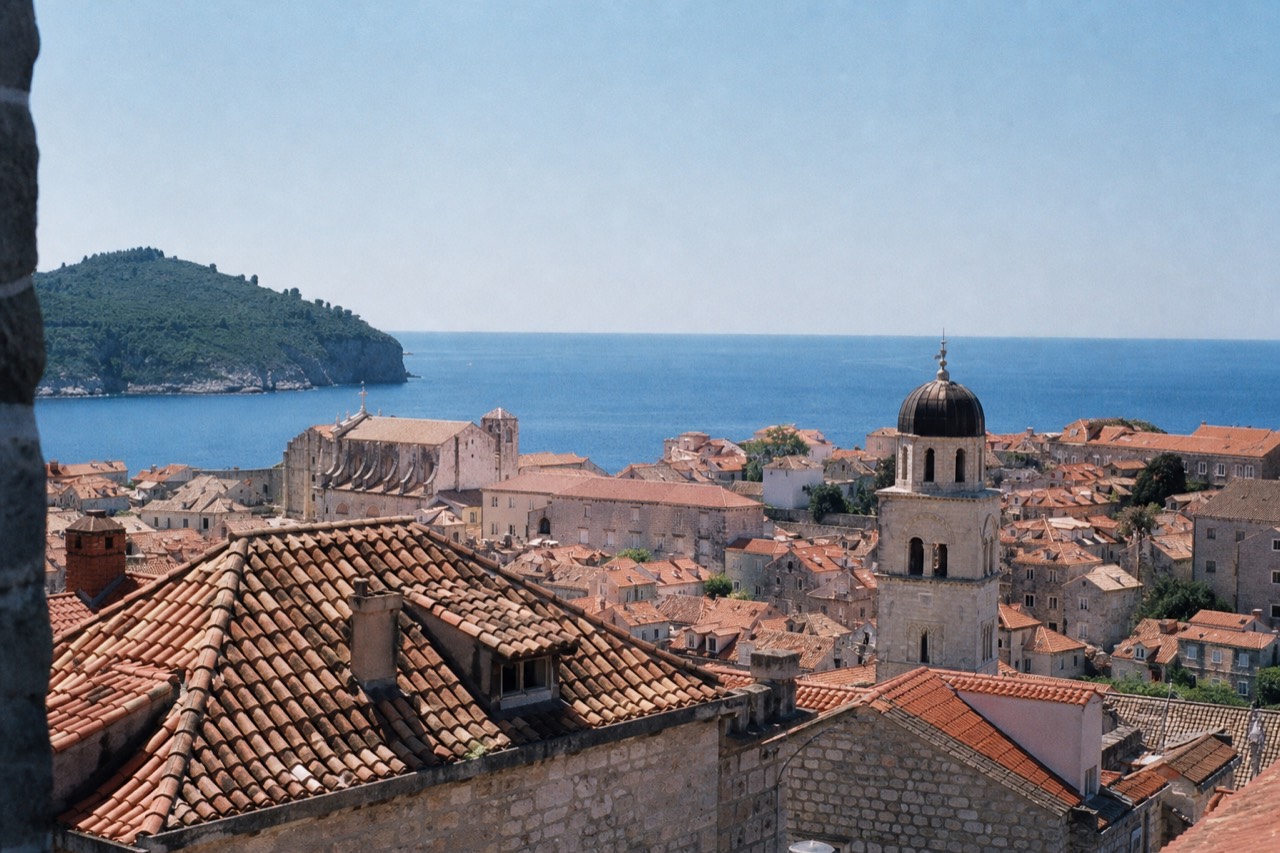 Sunlit limestone buildings and terracotta roofs of Dubrovnik Old Town under a clear summer sky