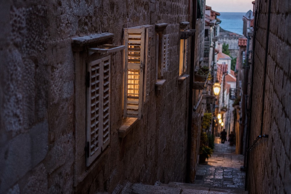 Shaded narrow side street in Dubrovnik Old Town with sunlight on stone steps