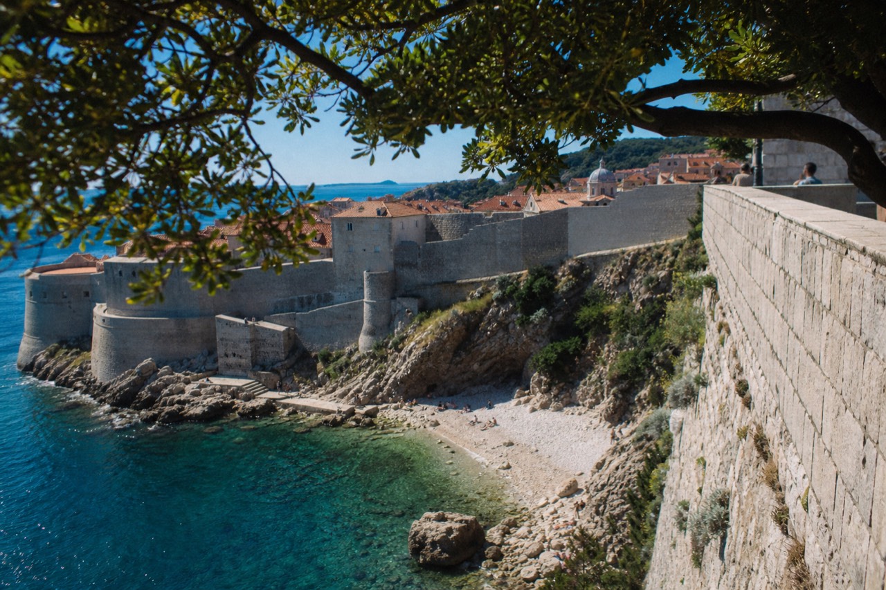 Stone city walls rising above red rooftops and the Adriatic sea