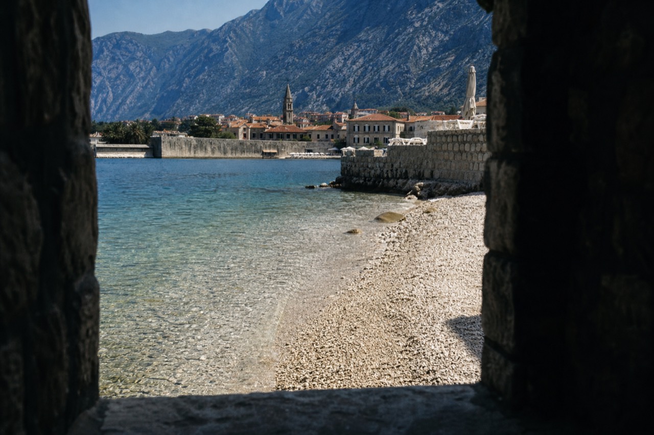 The walled Old Town of Kotor at the edge of its bay with mountains rising behind