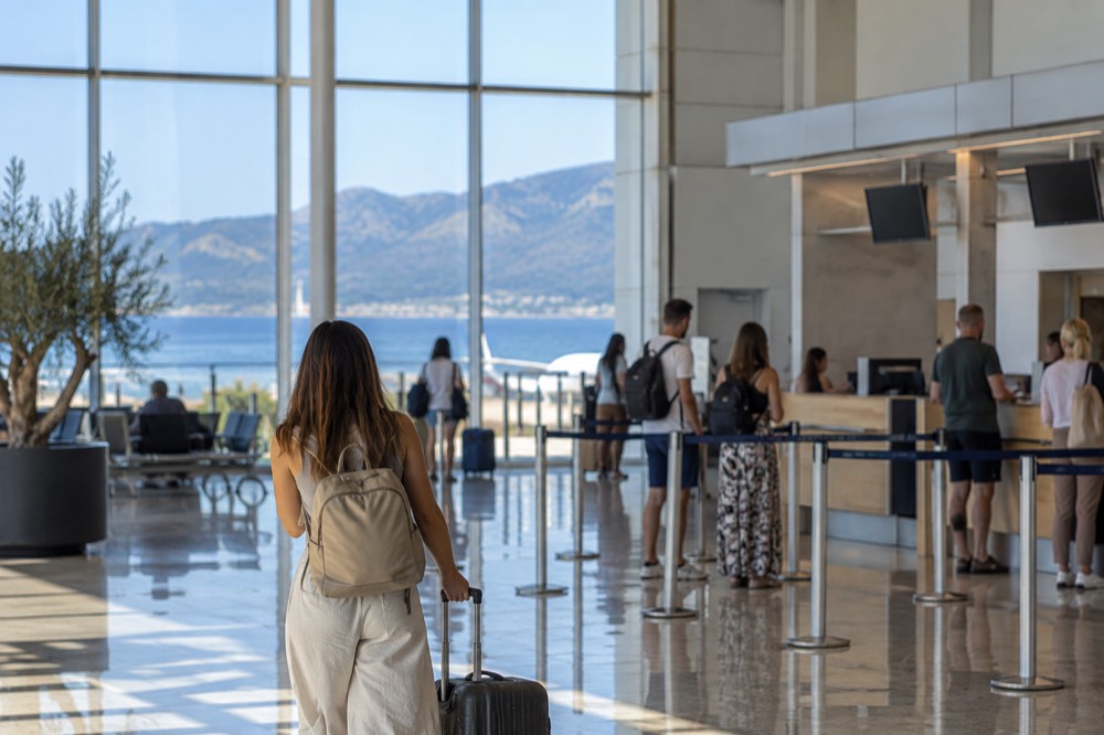 The check-in hall of a small coastal airport with morning light through tall windows