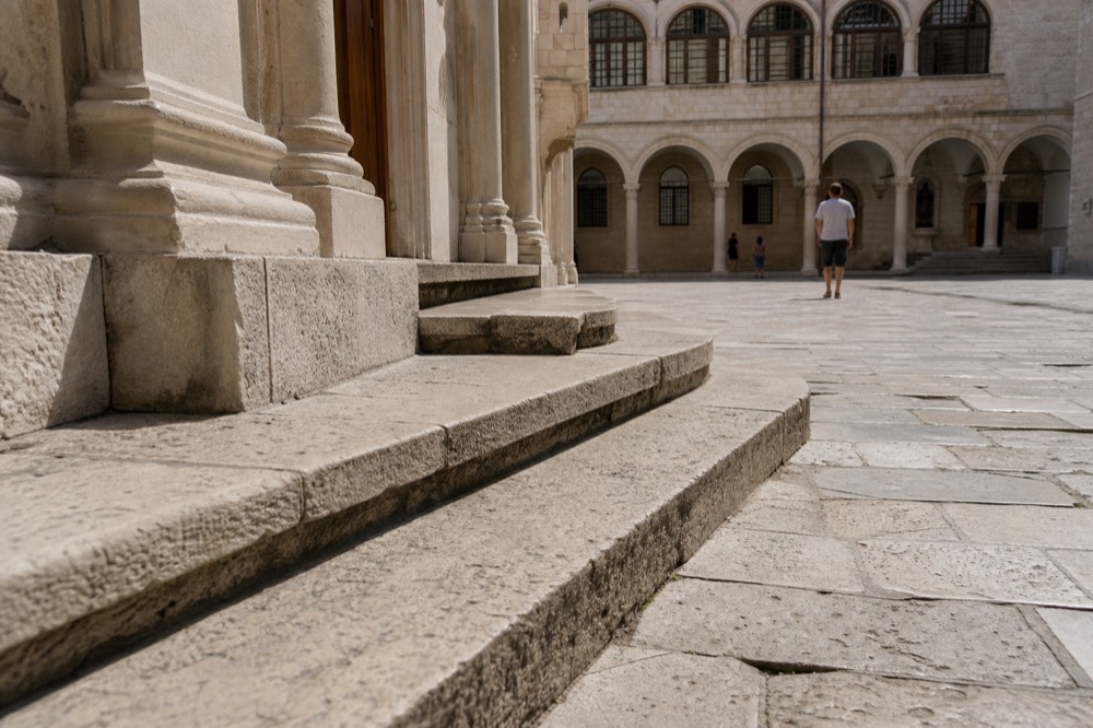 A stone staircase leading to a quiet courtyard inside the Rector's Palace, Dubrovnik.