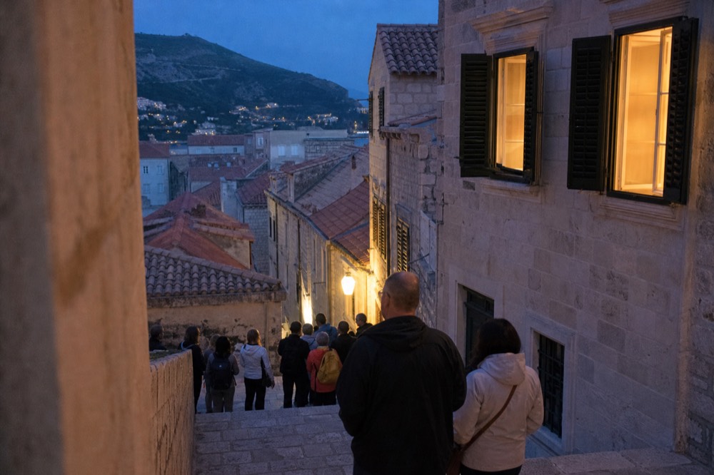 A guided walking group pausing on a limestone street inside Dubrovnik Old Town