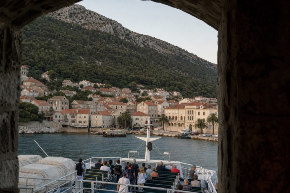 A passenger ferry approaching a small Croatian harbour town at midday