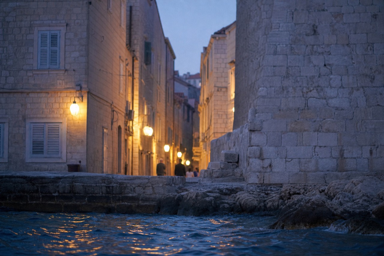 A quiet limestone street inside the walled Old Town of Dubrovnik with shuttered stone houses