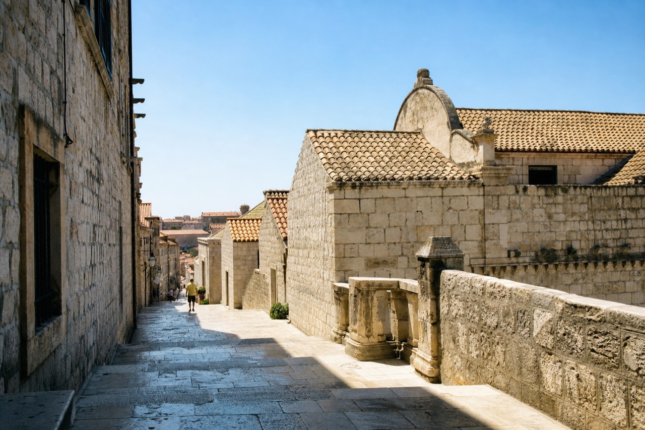 A limestone street in Dubrovnik Old Town with polished steps and stone buildings in morning light