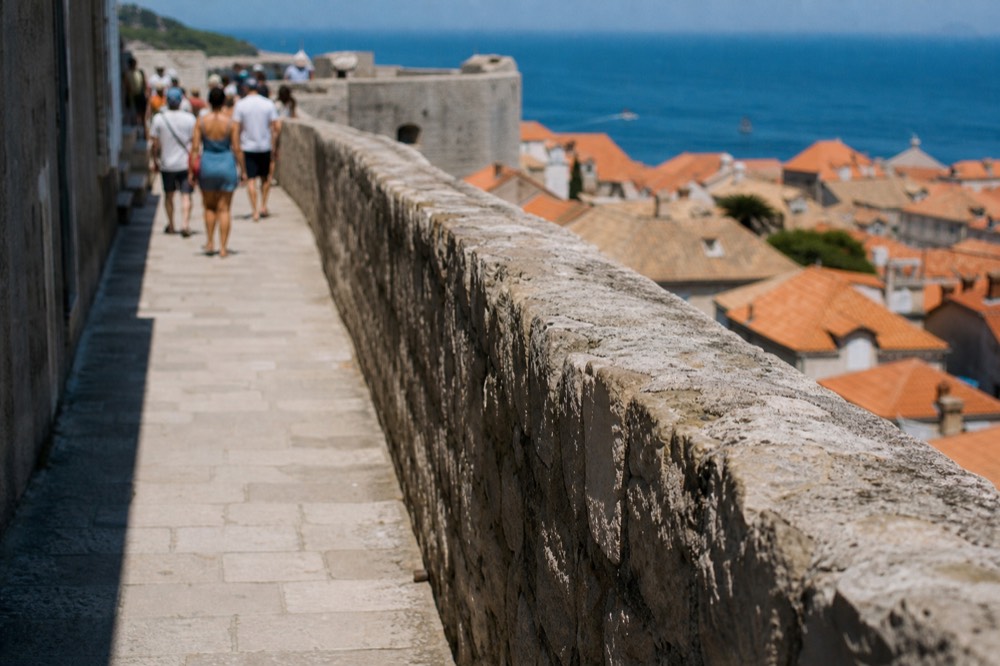 Fortified stone wall walkway above Dubrovnik old town rooftops