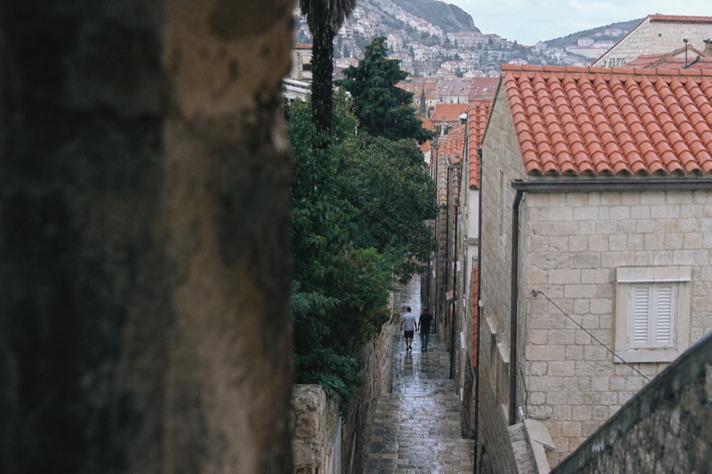 Limestone street in Dubrovnik Old Town lined with stone buildings under terracotta roofs