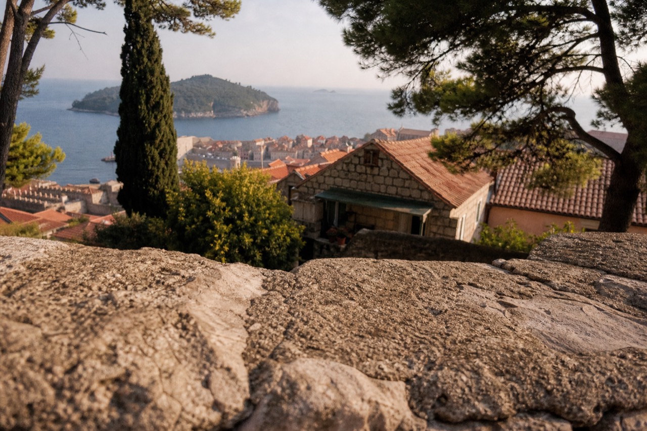 Stone rooftops of Dubrovnik Old Town with the Adriatic sea and island silhouettes beyond