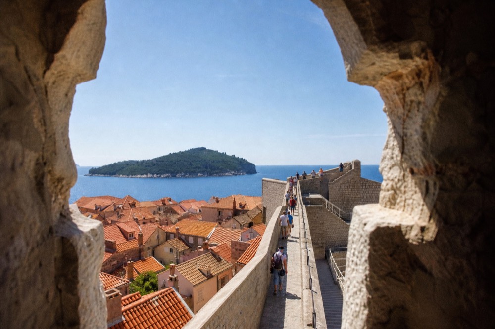 Visitors walking the high city walls above the red Old Town roofs