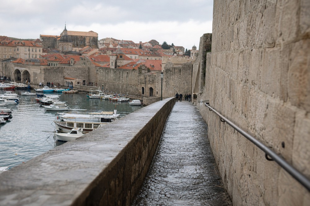Dubrovnik's Old Town harbour with terracotta roofs and the city walls rising behind