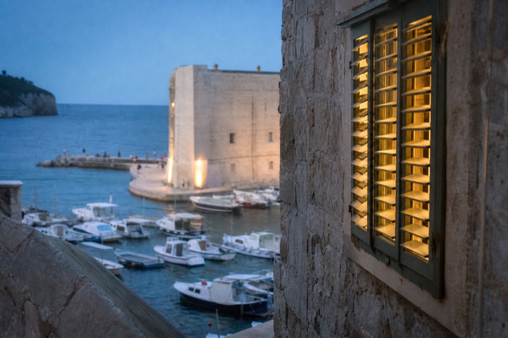 A view of the Old Town harbour from the city walls, with small boats and the Adriatic beyond