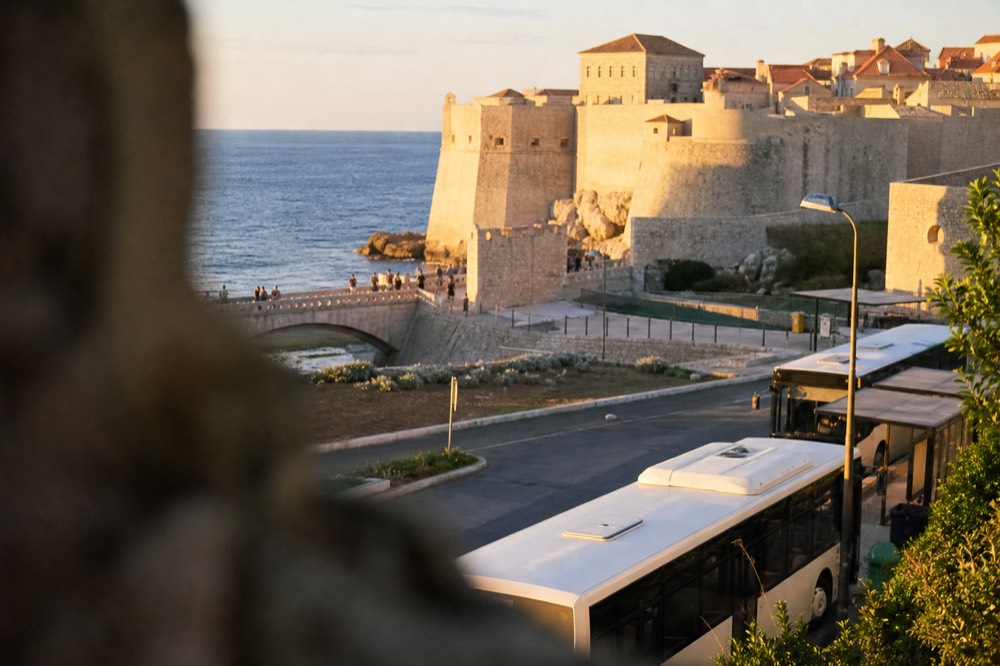 Local buses parked at the Pile terminus below the Old Town walls