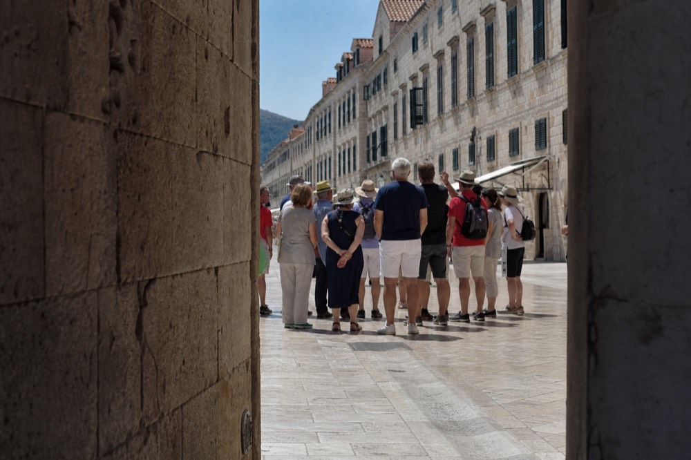 Guests on a guided walking tour listening to a guide on the Stradun in Dubrovnik