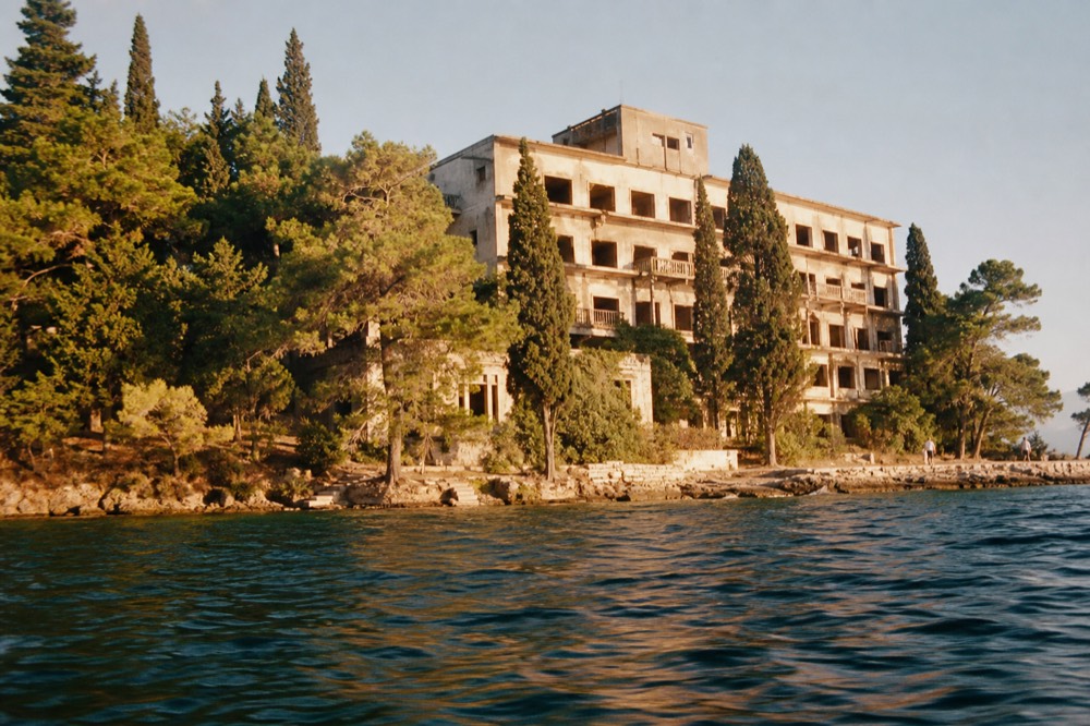 Golden evening light on a derelict hotel facade above the bay