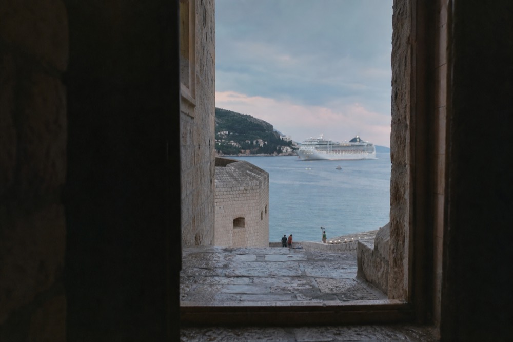 Cruise ship anchored off Dubrovnik Old Town walls at dusk