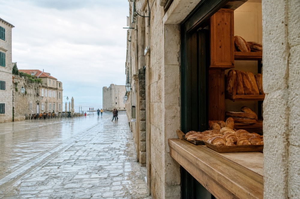 Bakery counter with fresh pastries and bread on wooden shelves