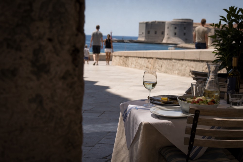 Evening table with simple grilled fish, salad and house wine at a small restaurant