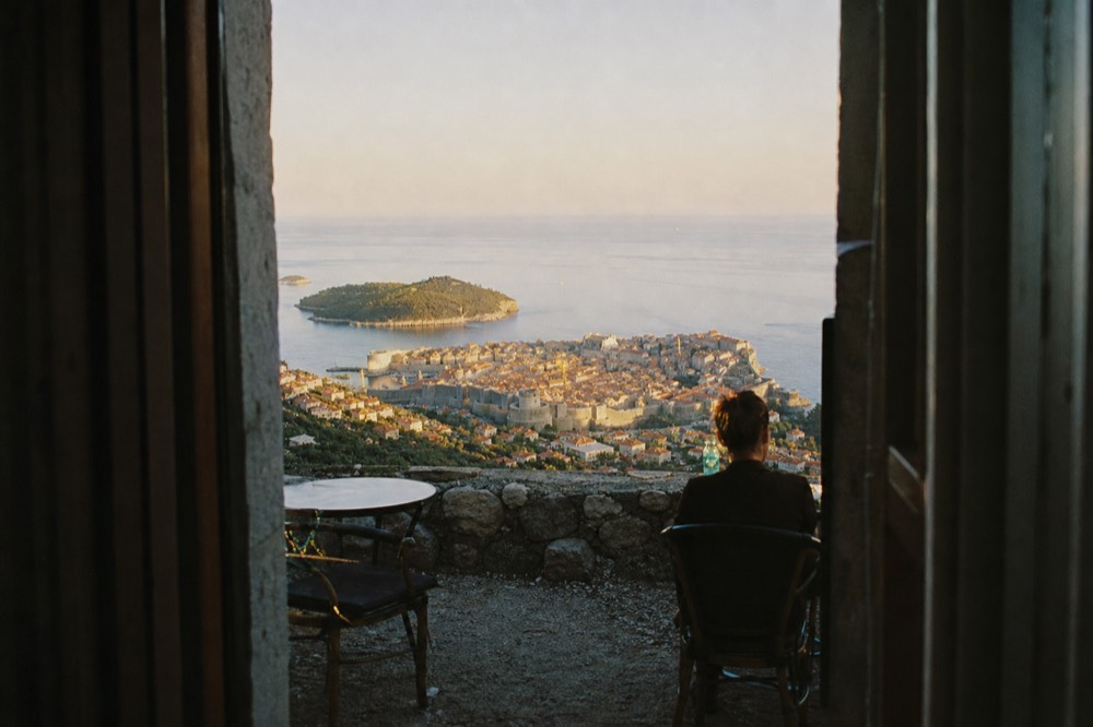 Evening view of Dubrovnik Old Town glowing under sunset light from the slopes of Mount Srd