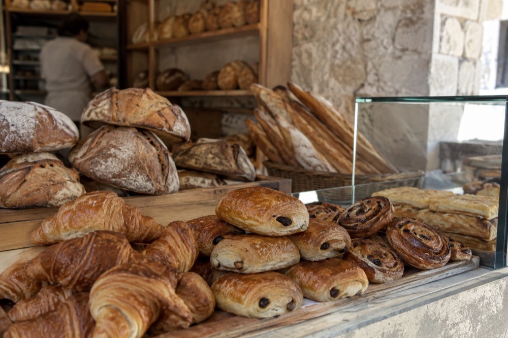 Fresh bread and pastries stacked behind the counter of a small Dubrovnik bakery
