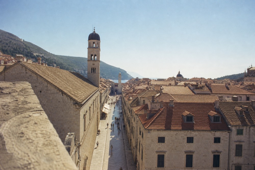 View from the wall top down the limestone Stradun toward the clock tower