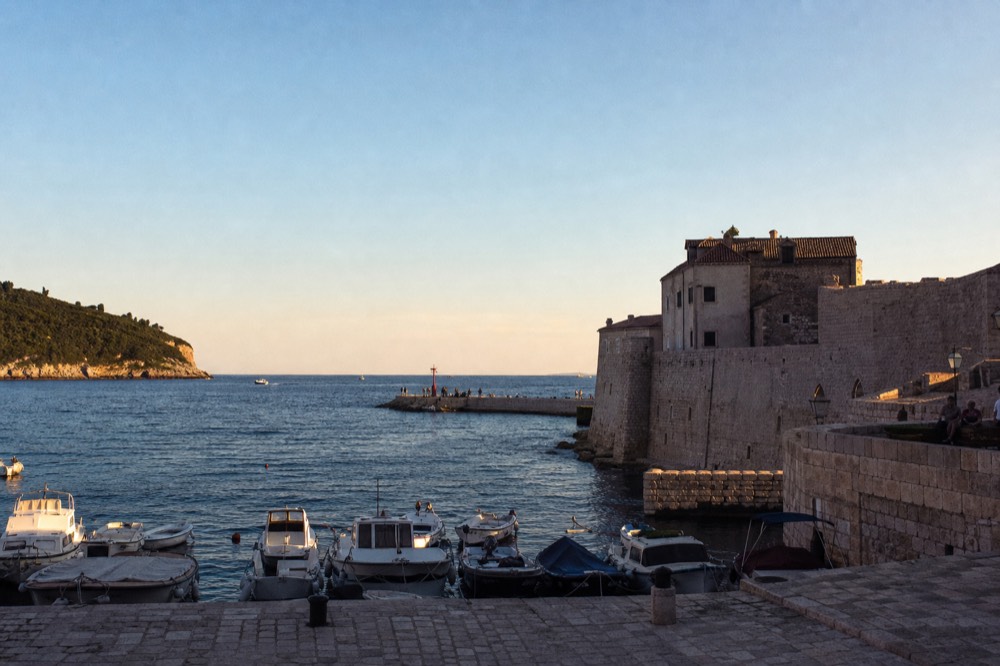 Old port with small boats and stone quay at the edge of the Old Town