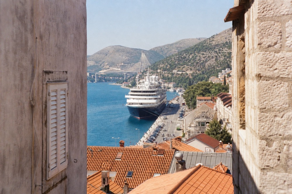 Cruise ship at berth in the late afternoon with the harbour road alongside