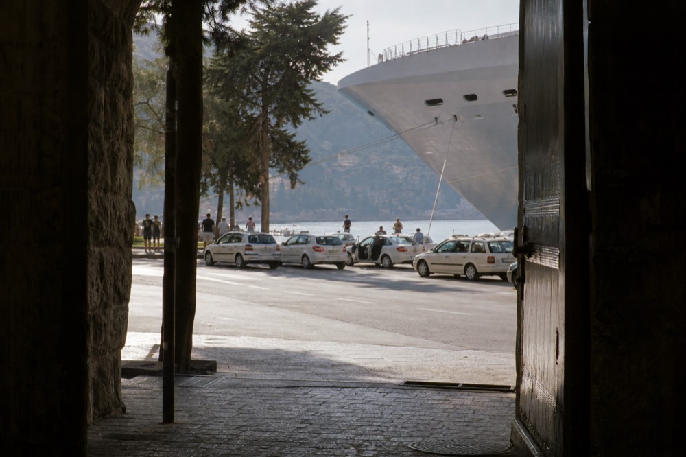 Taxi rank beside the cruise terminal with a ship's hull towering behind