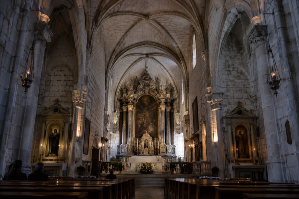 Interior of a stone church with vaulted ceiling and altarpiece