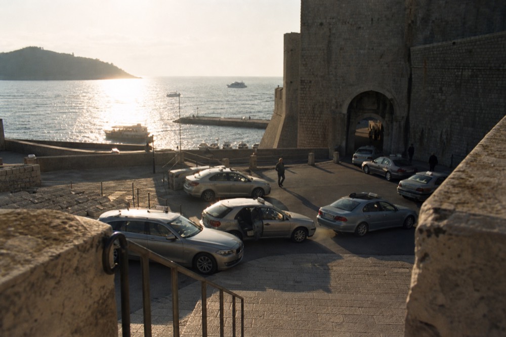 Taxi rank beside a stone gate and city walls in Dubrovnik
