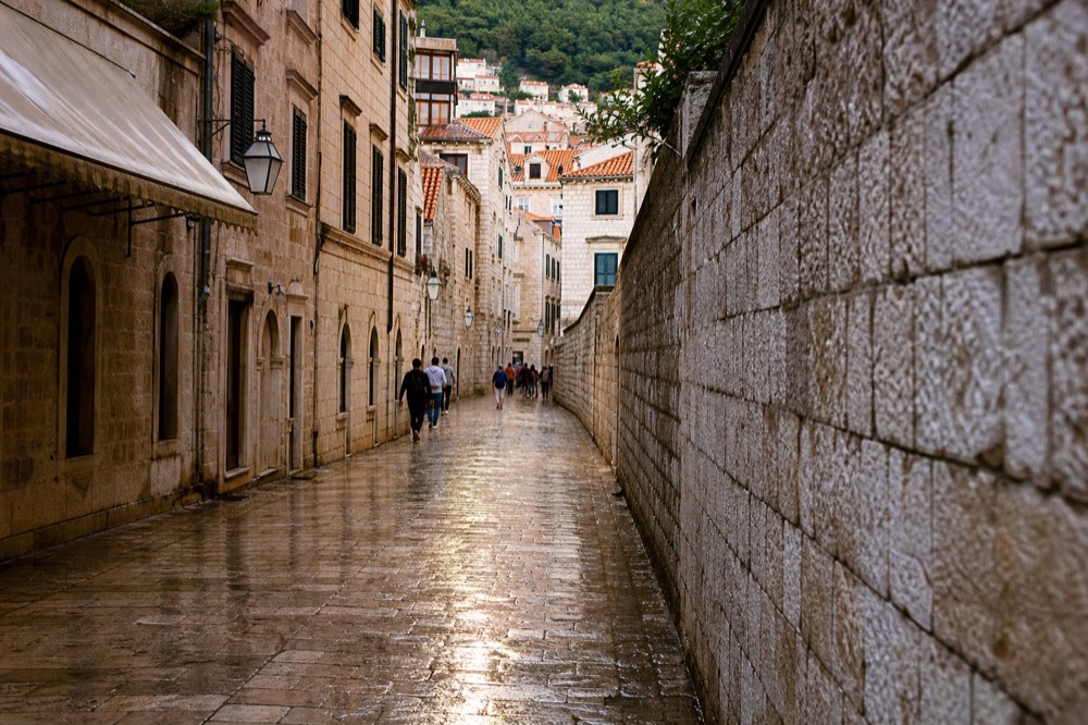 Limestone main street of Dubrovnik Old Town lined by stone buildings in evening light