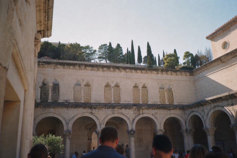 Interior courtyard of a historic Dubrovnik palace with stone arches and afternoon light
