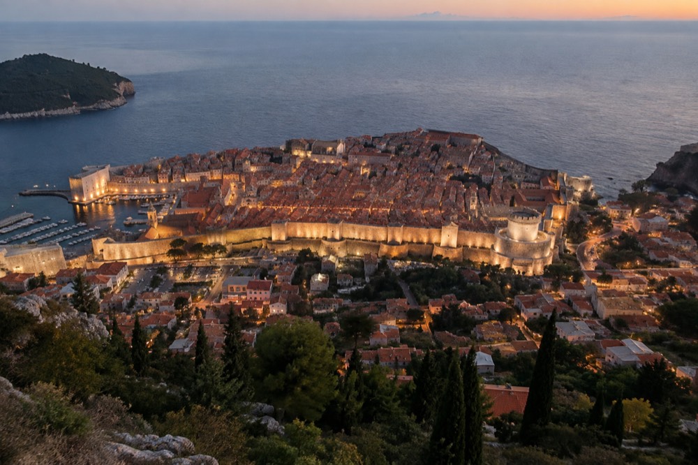 Dubrovnik Old Town rooftops and the illuminated city walls at dusk seen from Mount Srd