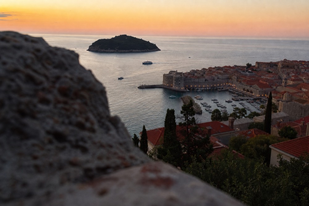 Dubrovnik Old Town and harbour lights at dusk seen from the hillside above the city