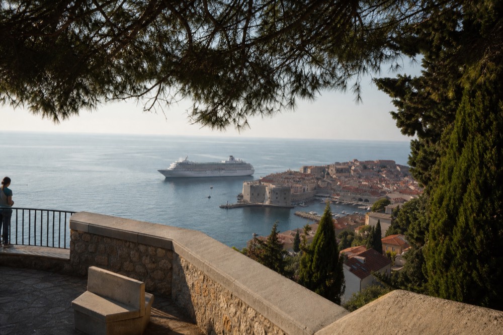 A cruise ship anchored off the walled city of Dubrovnik in autumn