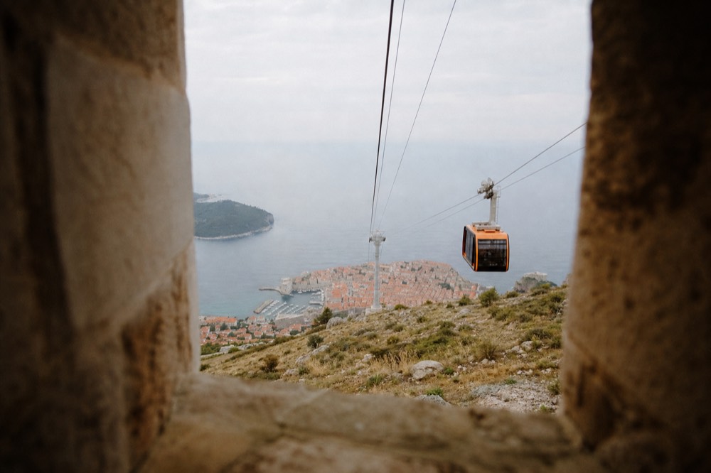 Cable car cabins above Dubrovnik with autumn haze over the Adriatic