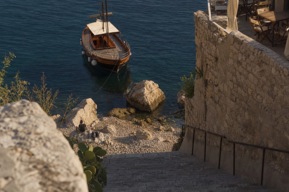A wooden boat moored in Dubrovnik Old City Harbour in the late afternoon