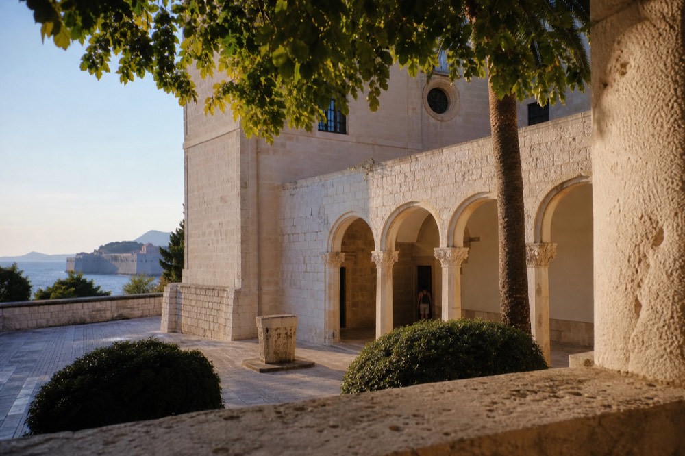 Entrance courtyard of a Dubrovnik museum with stone arches and warm afternoon light