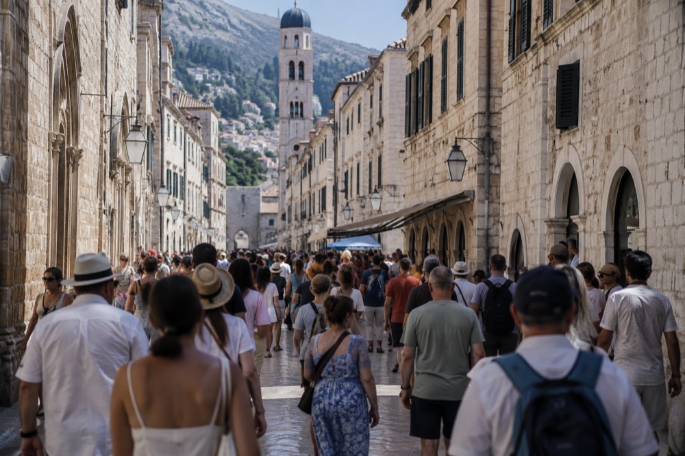 A crowded stone street with visitors walking between historic buildings